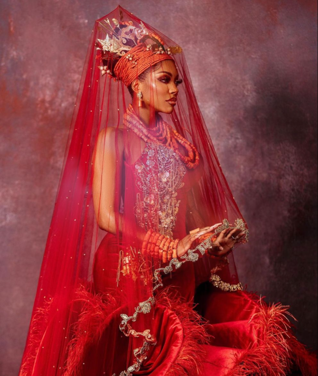 Red traditional nigerian outfit with intricate designs on a dark background